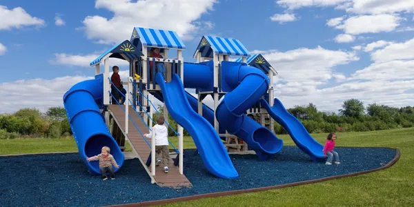 A group of people playing on some slides