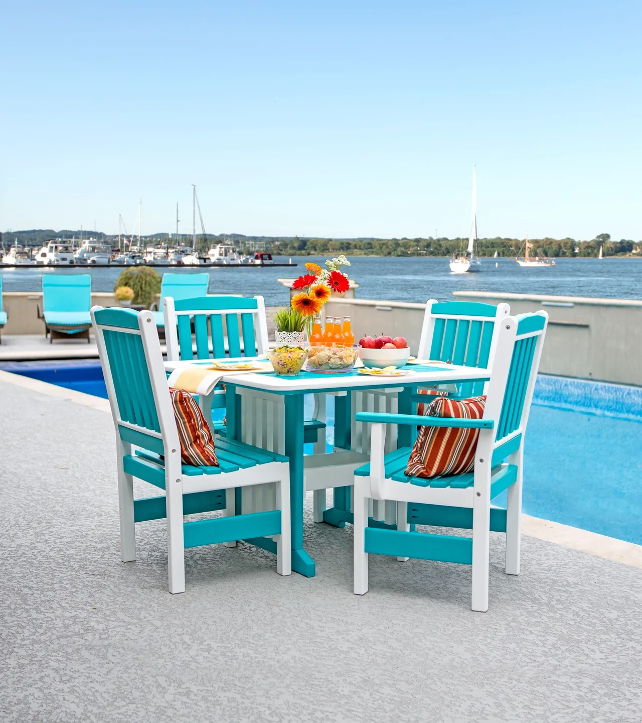 A table and chairs set up in front of the pool.