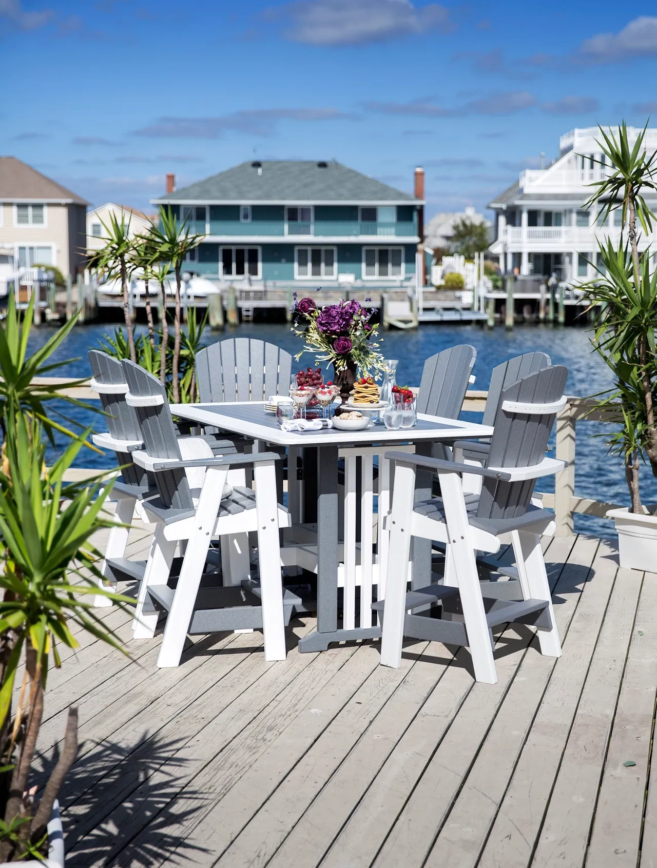 A table and chairs set on the deck of a dock.