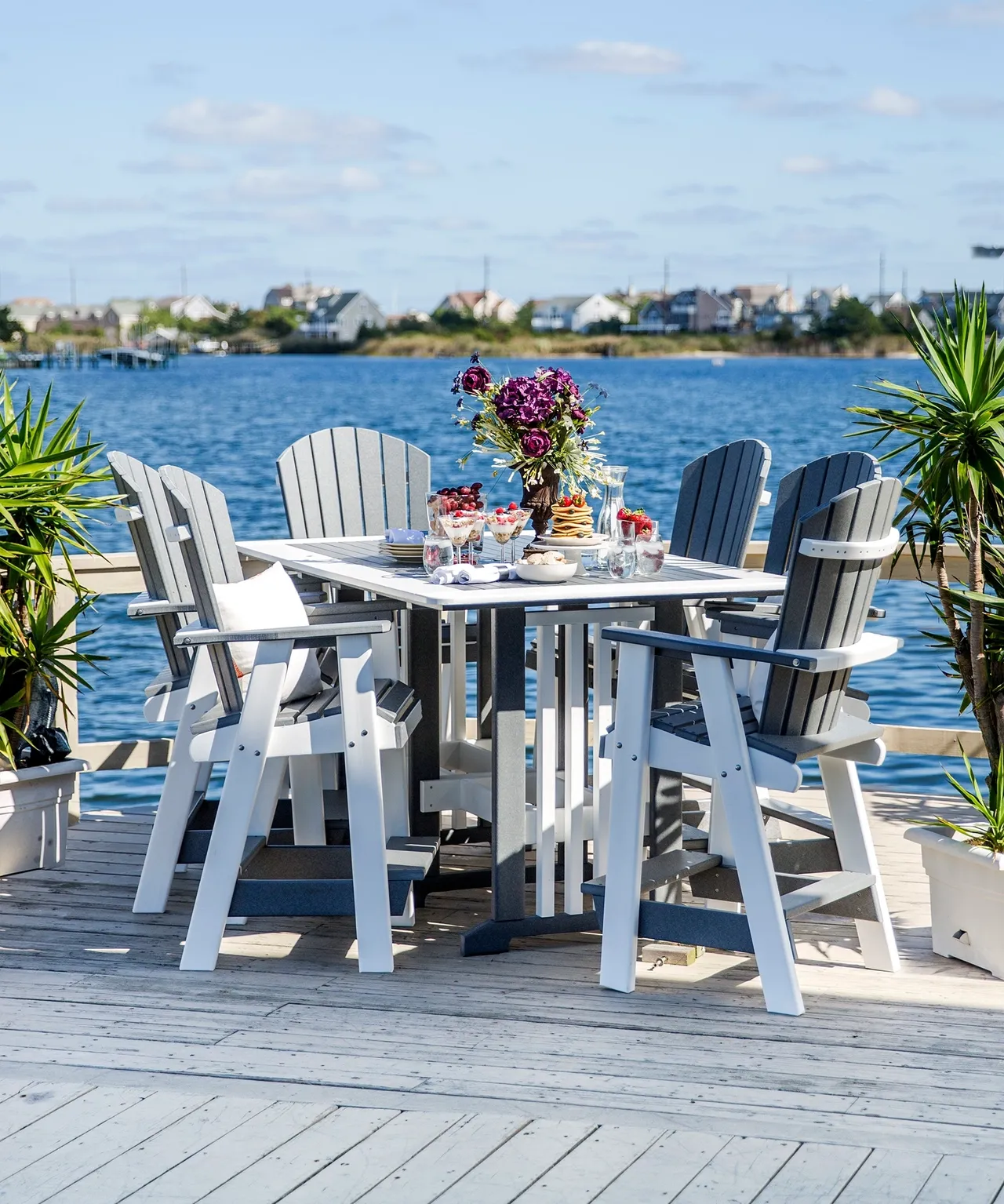 A table and chairs set up on the deck of a dock.
