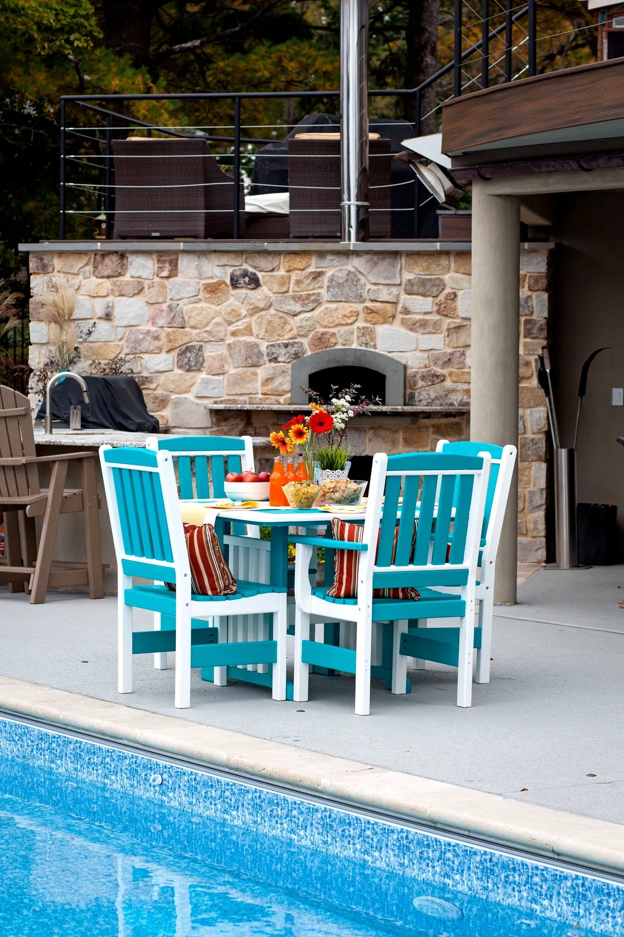 A table and chairs set up in front of the pool.