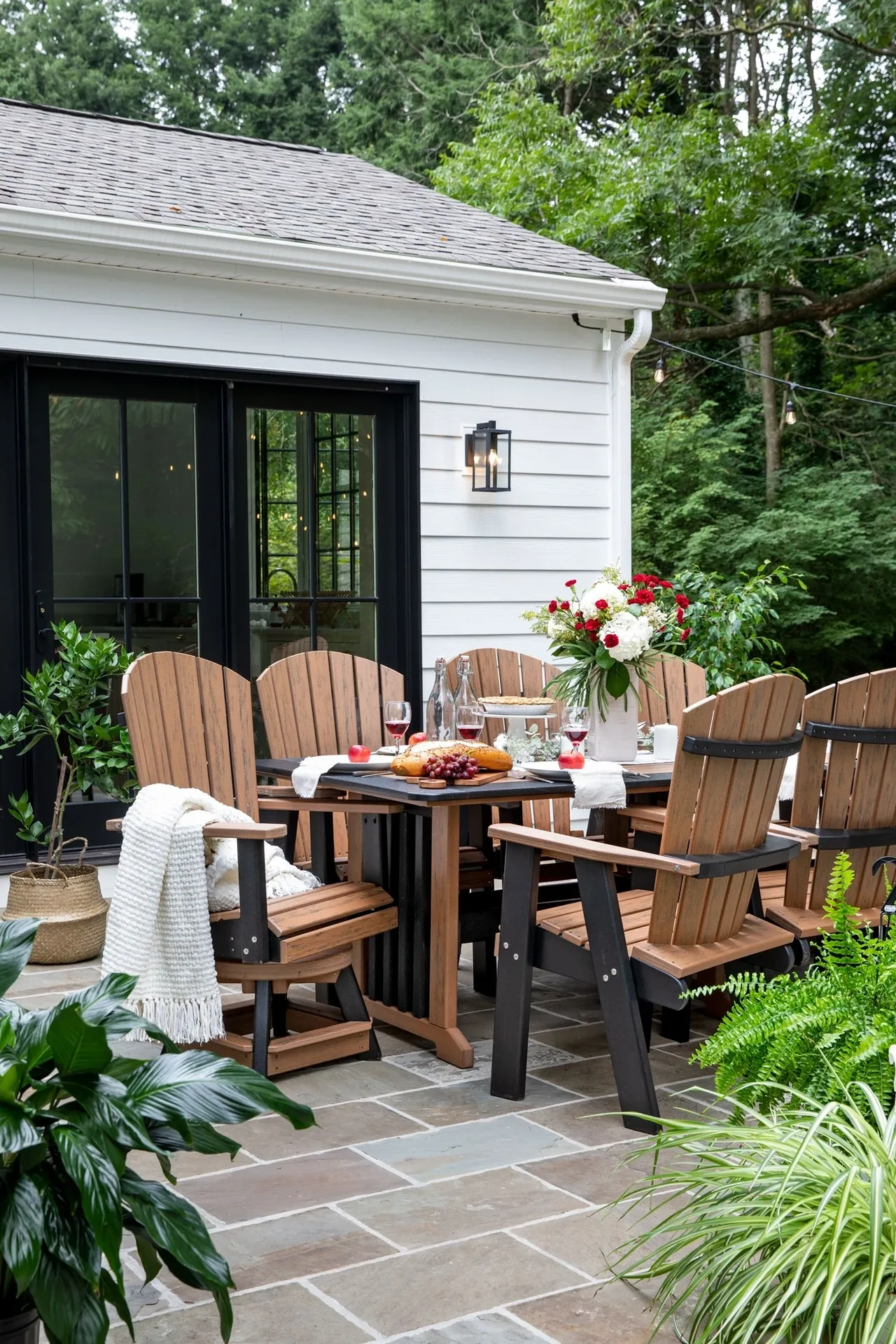 A patio set with table and chairs in front of a house.