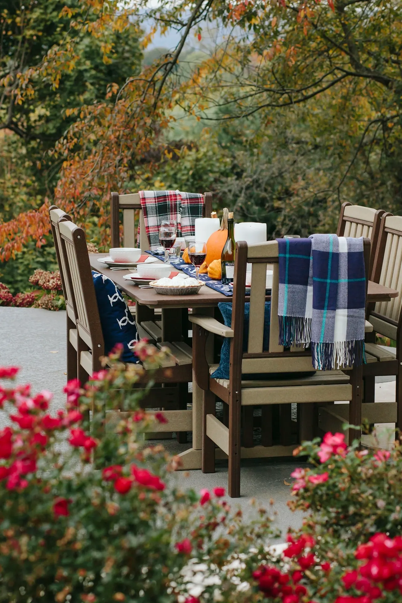 A table with chairs and flowers in the background.