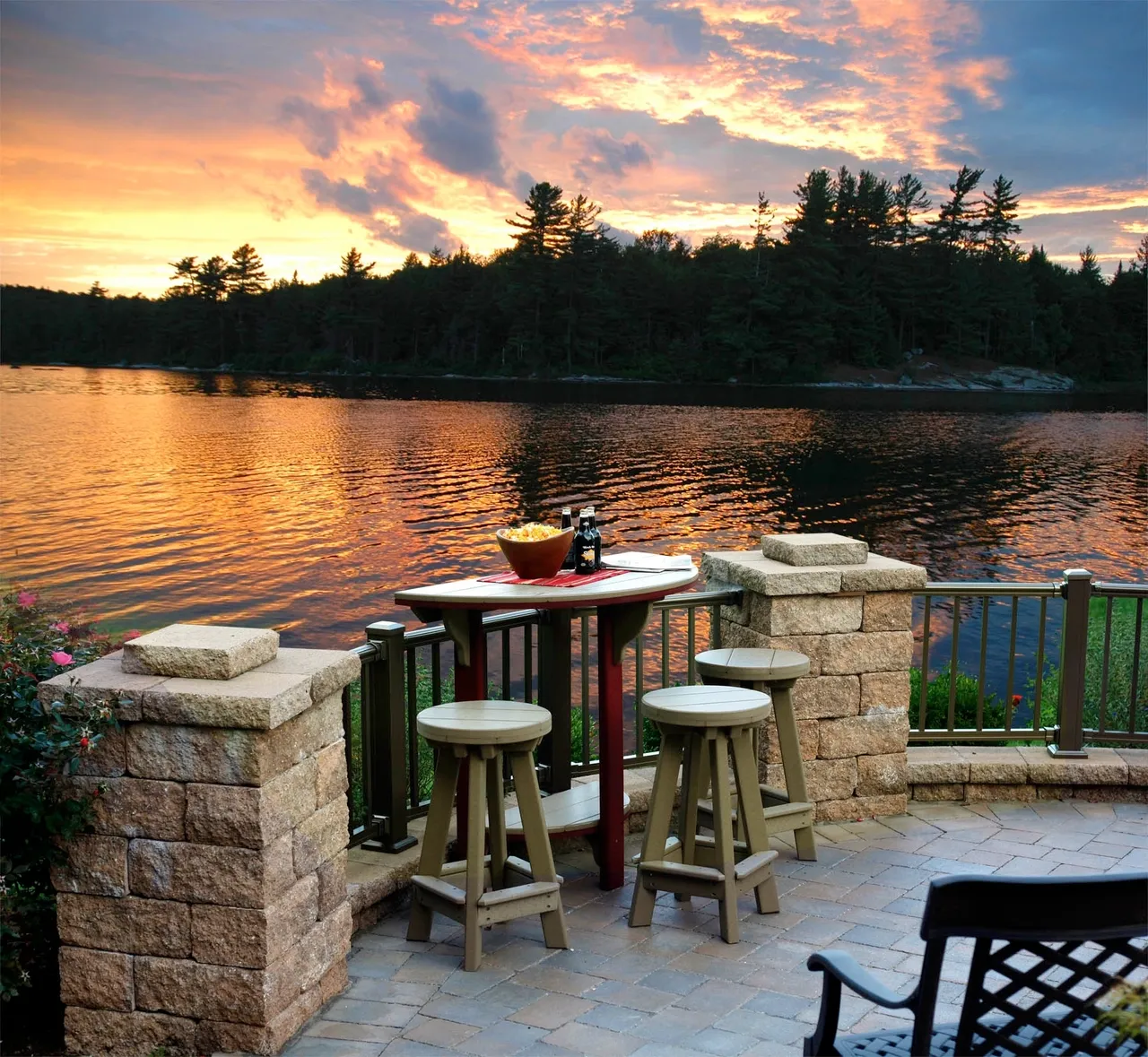 A patio with chairs and tables overlooking the water.