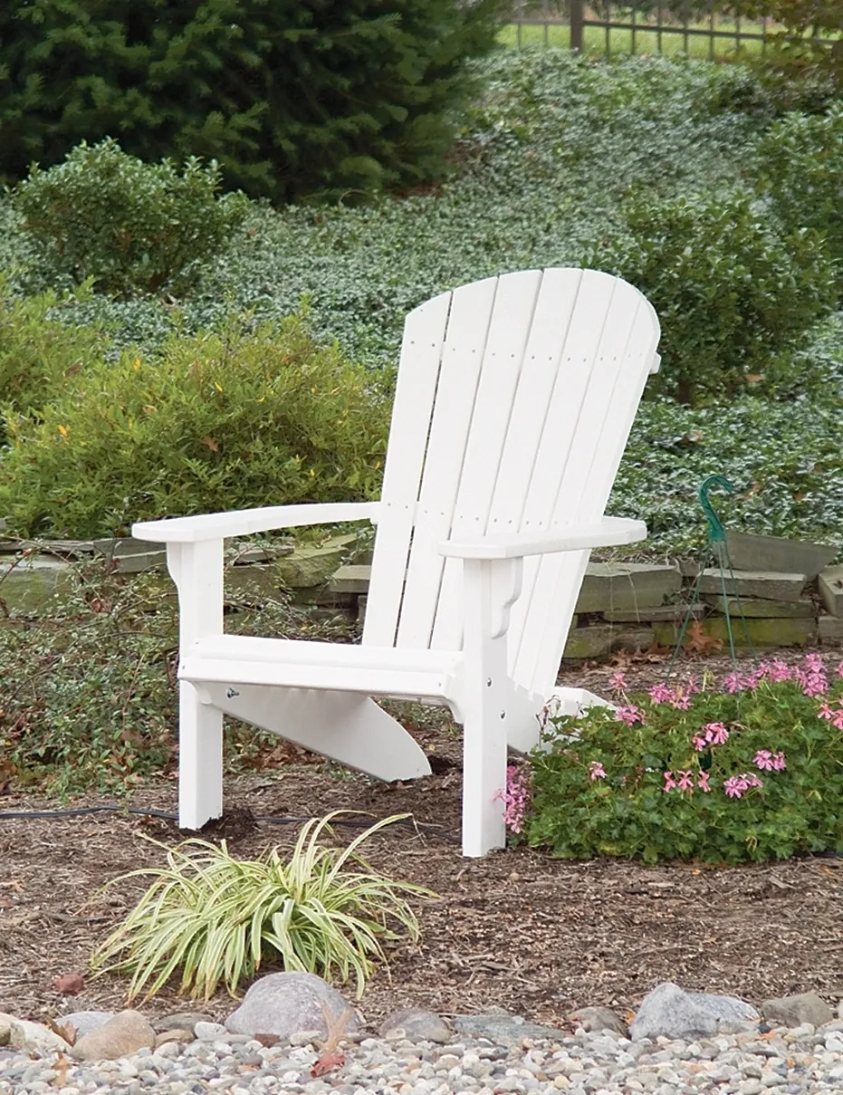 A white chair sitting in the middle of some bushes.