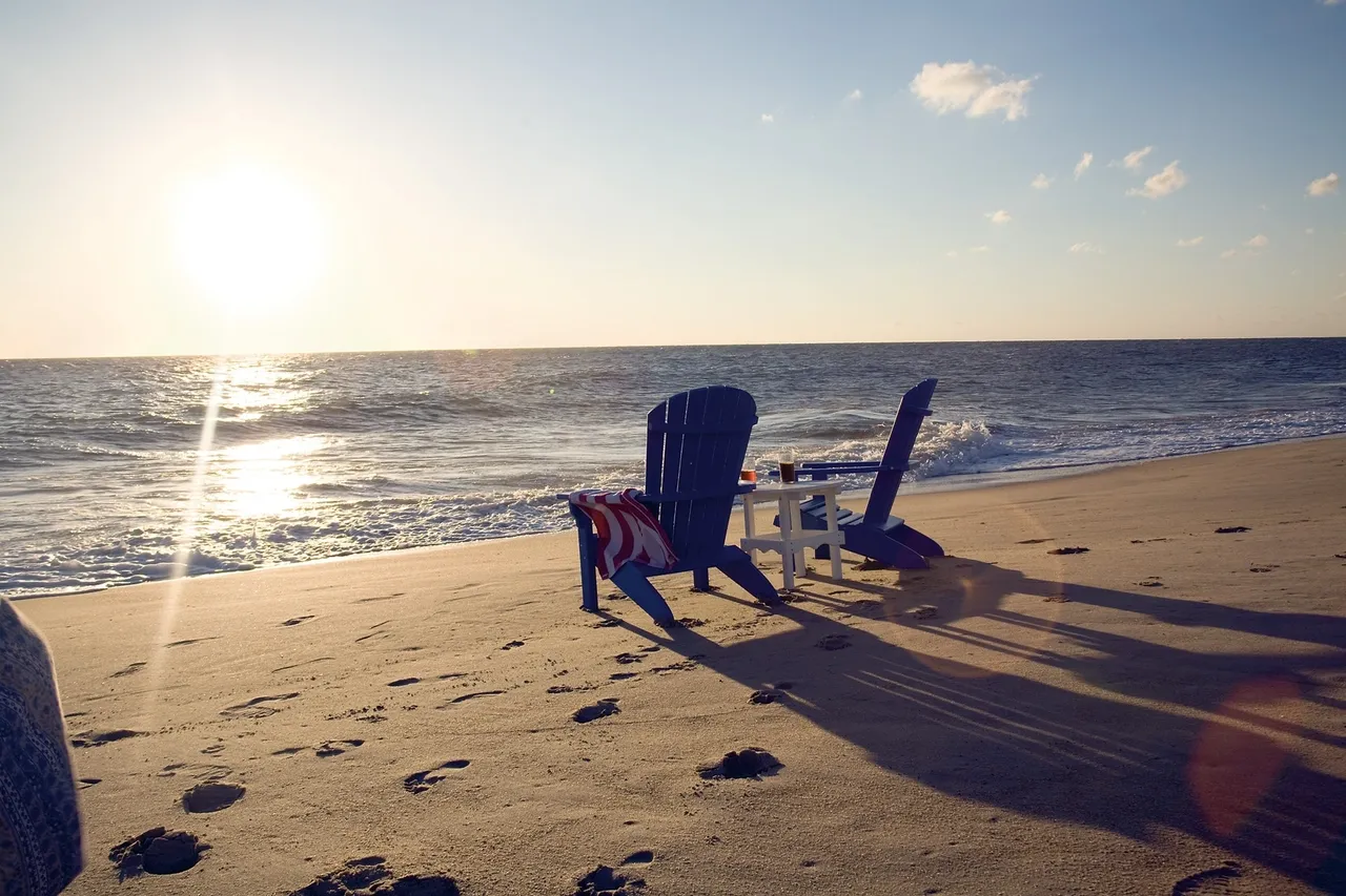 A beach with chairs and tables on it