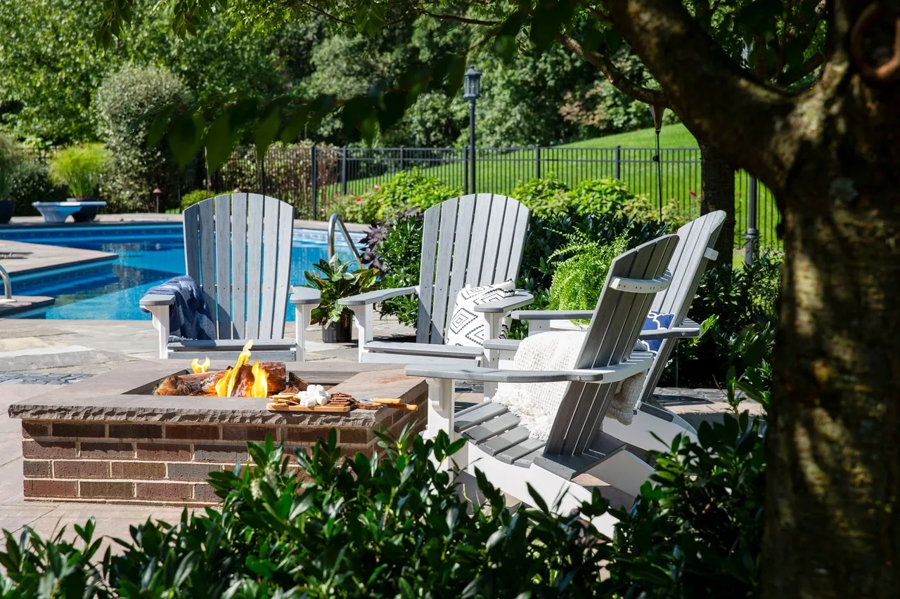 A group of chairs sitting next to a fire pit.