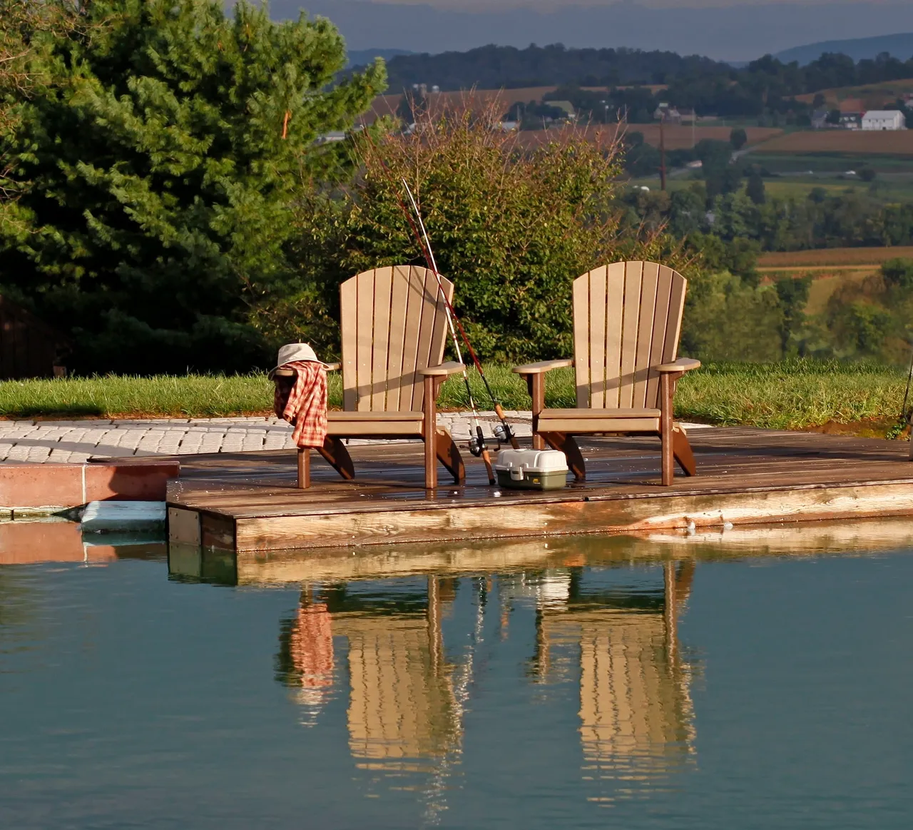 Two chairs on a dock with water in the background