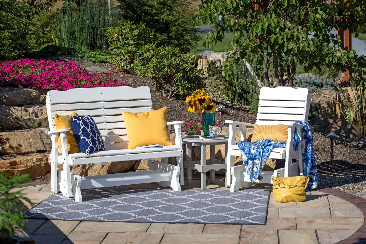 A couple of white chairs sitting on top of a brick patio.
