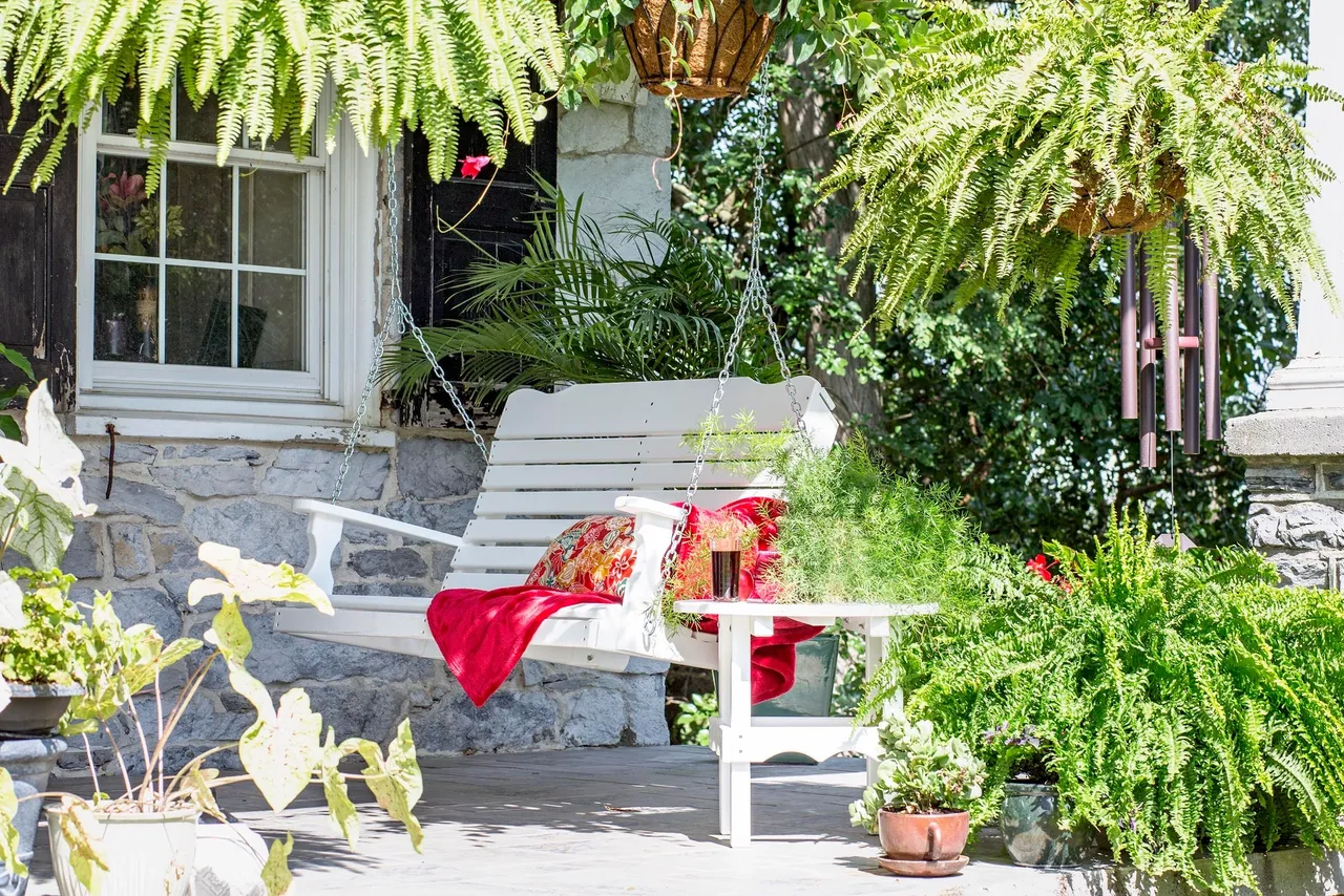 A white bench sitting in front of a house.