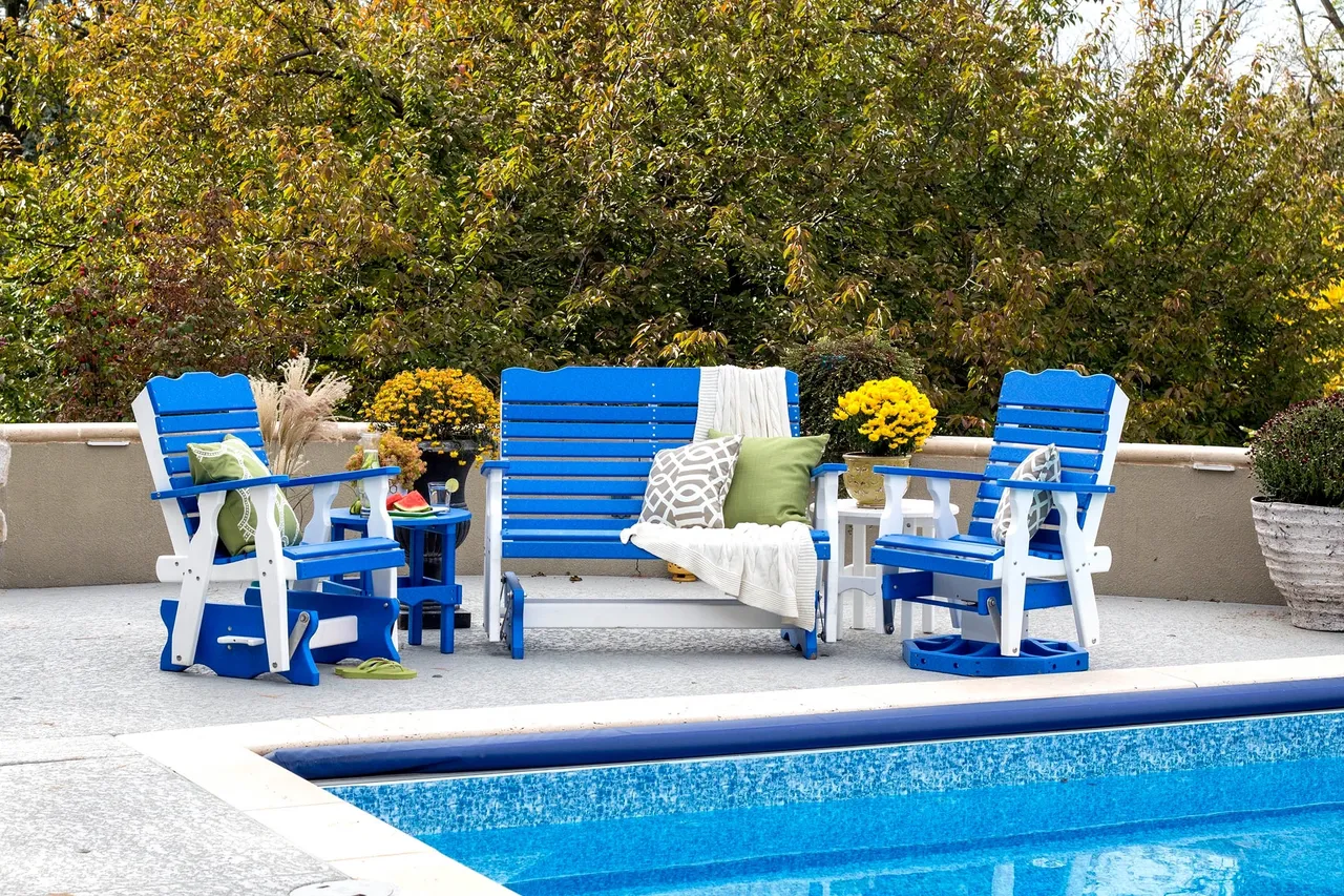 A pool with blue and white furniture next to the water.