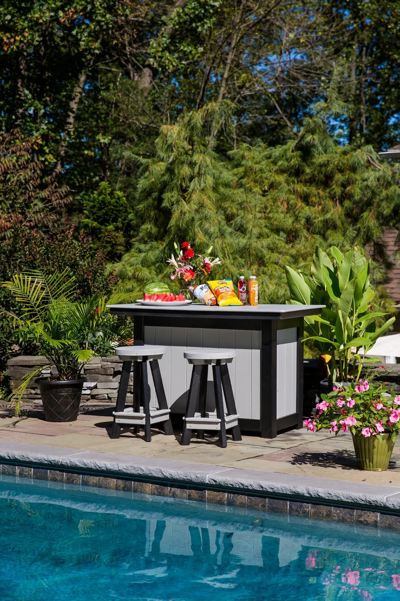 A table with fruit on top of it near the pool.