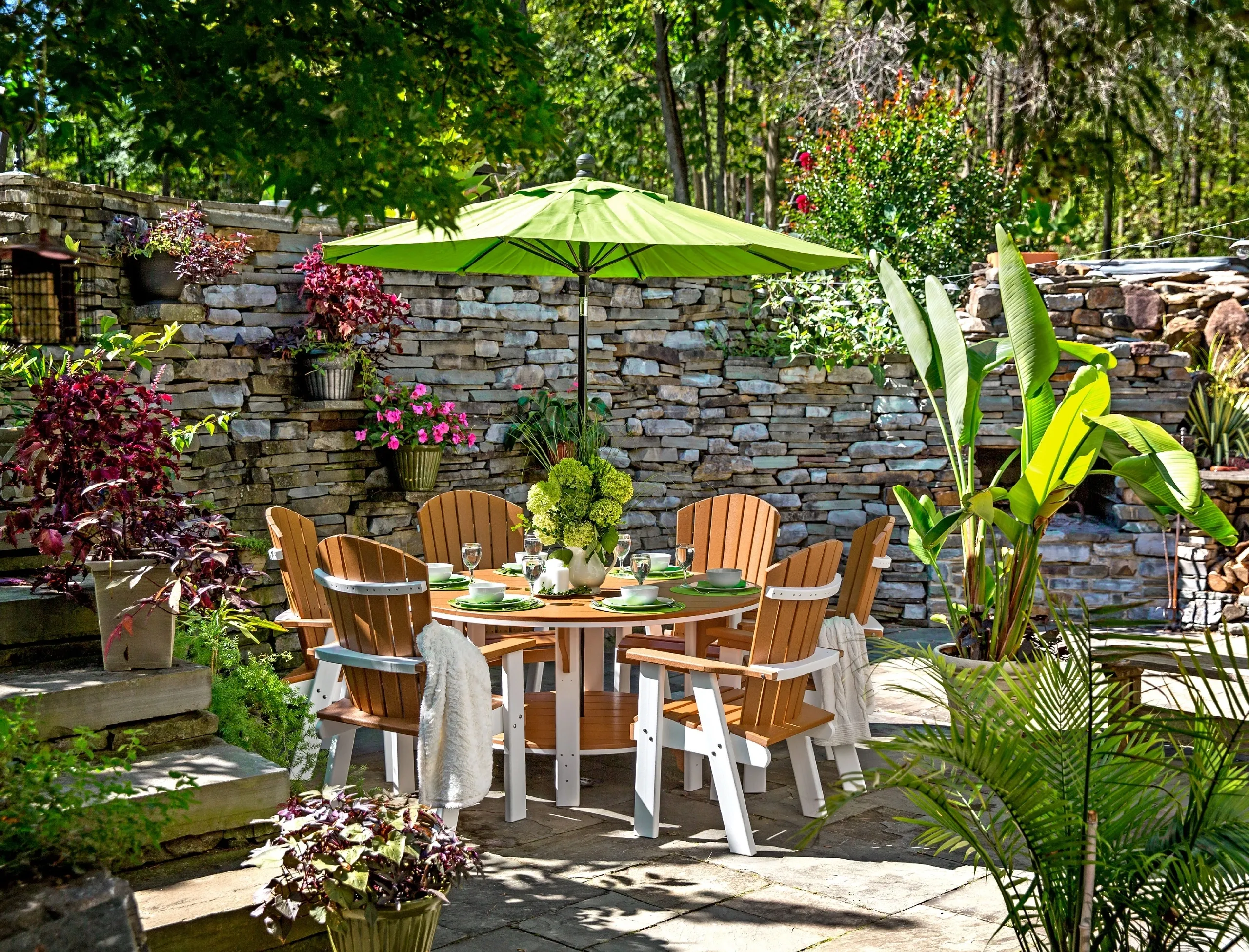 A patio with an umbrella and chairs in the middle of it